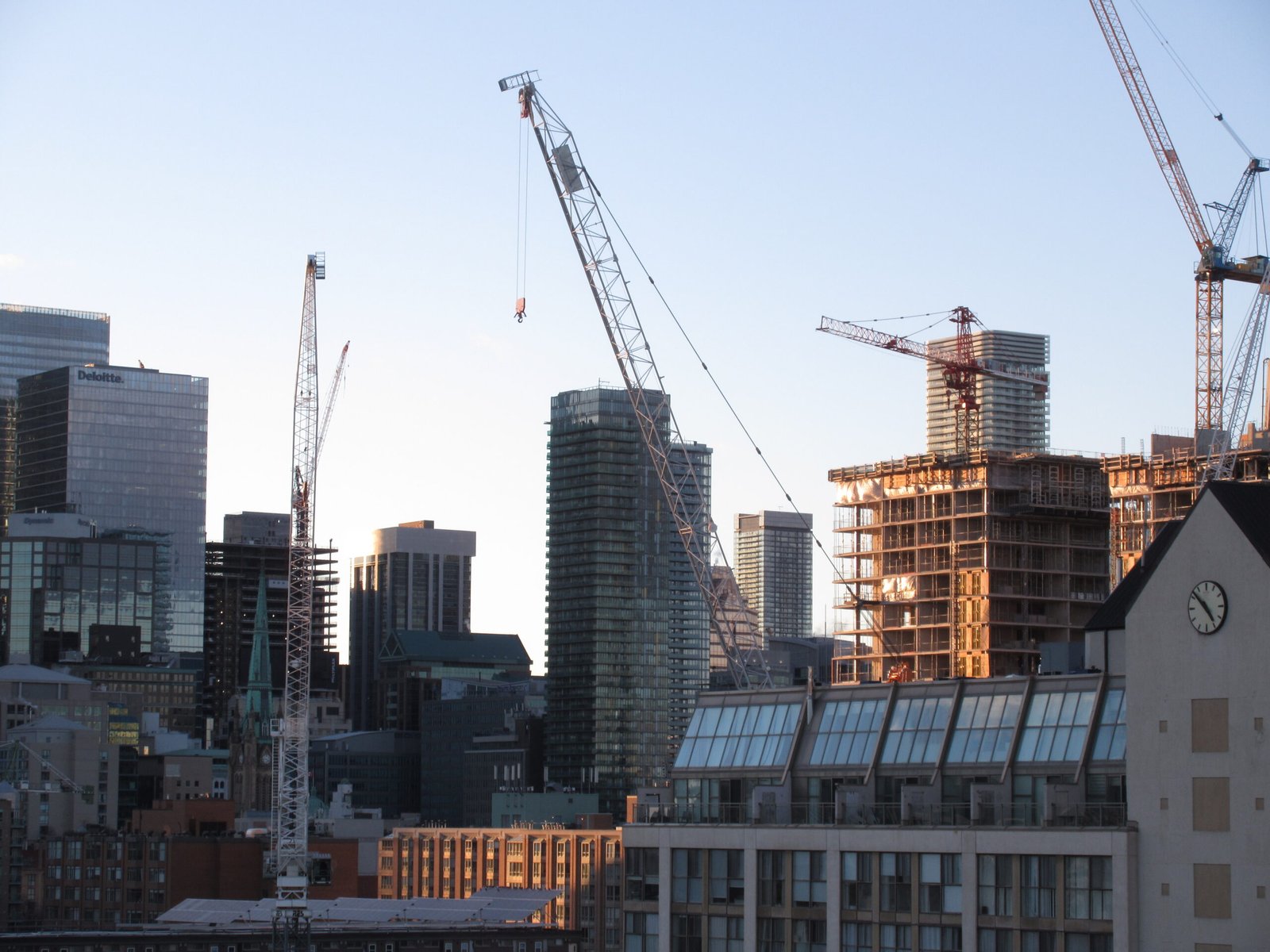 Construction cranes on the Toronto skyline, representing large-scale institutional capital projects across North America