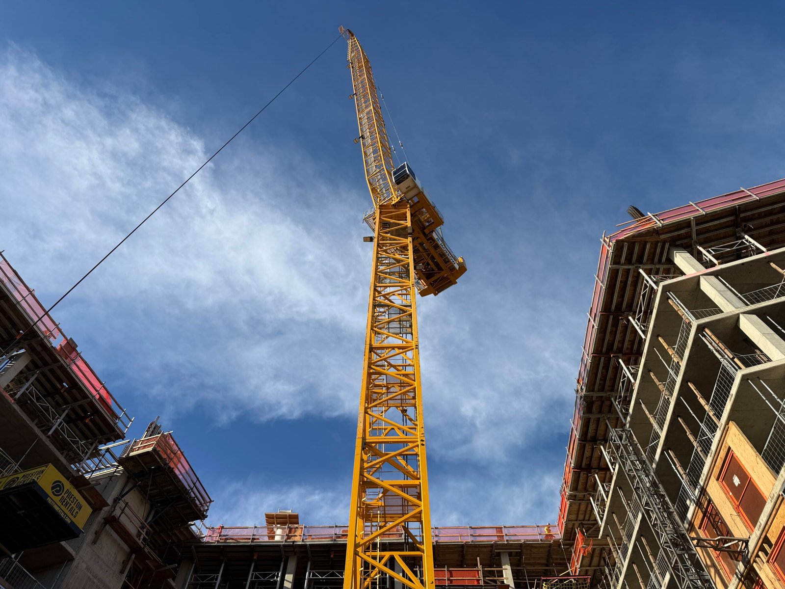 Tower crane at a large mixed-use construction site, illustrating institutional-scale infrastructure and capital-project delivery